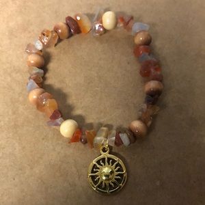 Orange beaded bracelet with sun charm